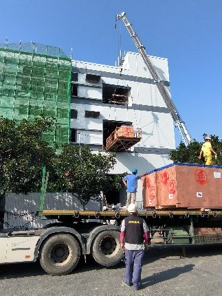 吊車將裝箱後的精密設備吊運至客戶廠區指定位置